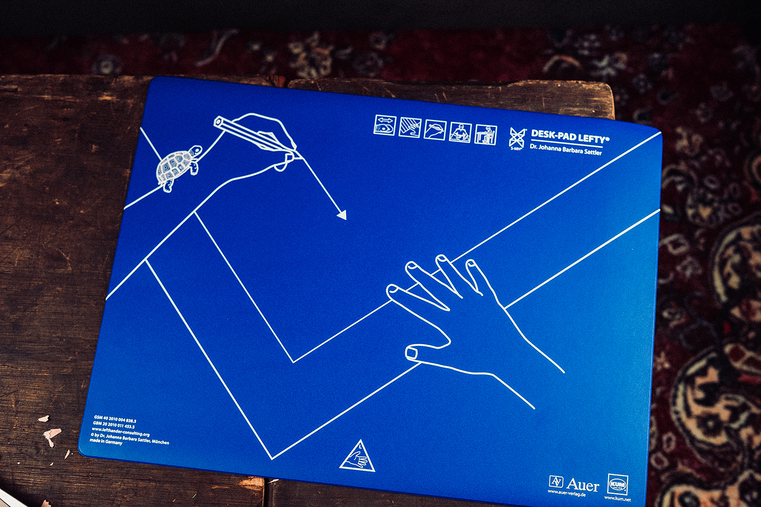 Blaue KUM Desk-Pad Lefty Schreibunterlage mit aufgedruckter Hand- und Blatthaltungs-Zeichnung von Dr. Johanna Barbara Sattler